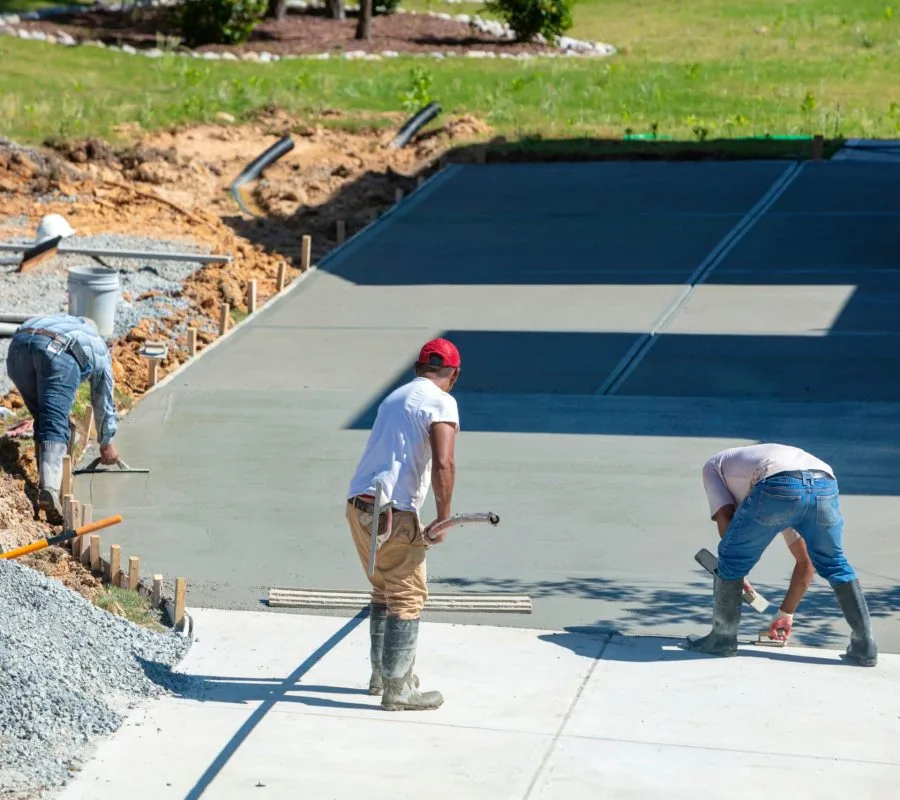 Unidentifiable hispanic men working on a new concrete driveway at a residential home