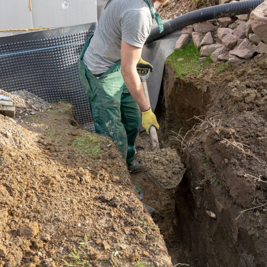 A man Digging ground to prepare for drainage home.